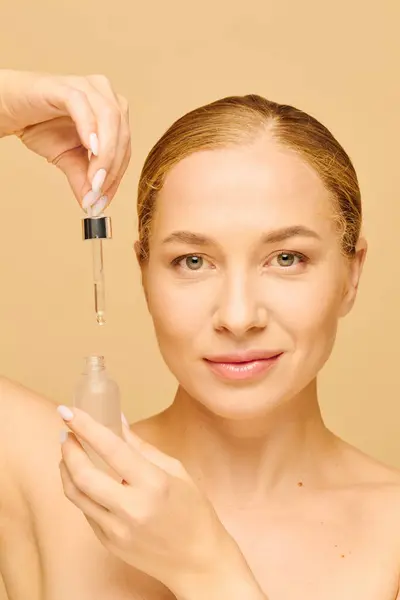 Questa giovane donna applica gioiosamente la cura della pelle, evidenziando la sua naturale bellezza e fiducia. — Foto stock