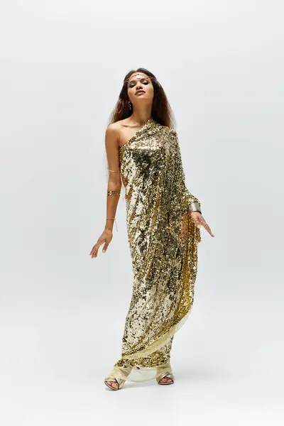 This captivating woman exudes elegance in a golden dress, showcasing her beauty in soft studio lighting. — Stock Photo