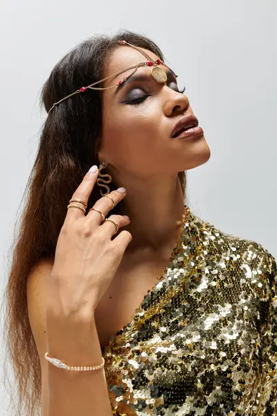 A breathtaking African American goddess showcases her beauty in a dazzling golden dress, exuding confidence. — Stock Photo