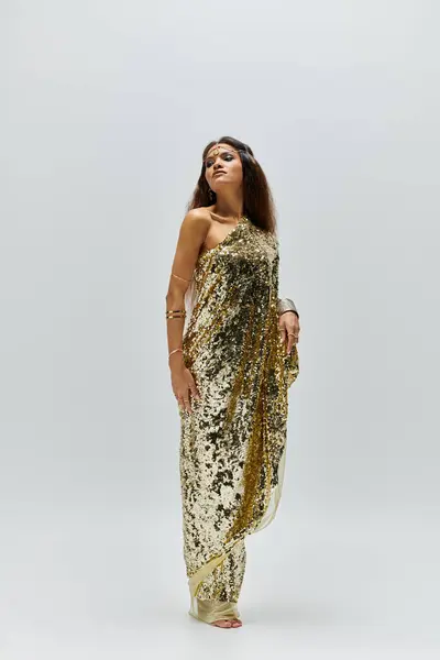 A captivating African American woman poses gracefully in a shimmering golden dress, showcasing her elegance. — Stock Photo