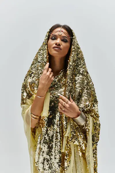 An African American woman adorned in a gleaming golden dress exudes elegance in an artistic studio environment. — Stock Photo