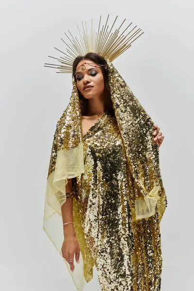 This captivating figure exudes grace and beauty in a shiny golden dress with a radiant headdress. — Stock Photo