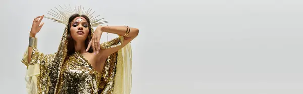 A stunning African American woman dazzles in a golden dress, showcasing elegance and grace in a studio. — Stock Photo