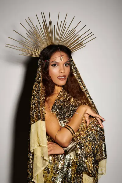 A radiant African American goddess captivates with her shiny golden dress and striking presence in the studio. — Stock Photo