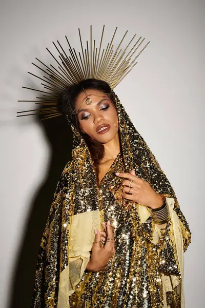 A radiant African American goddess captivates in a golden dress, exuding elegance and charm under studio lights. — Stock Photo
