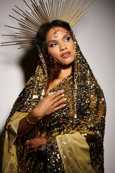 A magnificent African American woman stands gracefully in a shiny golden dress, exuding beauty and strength. — Stock Photo