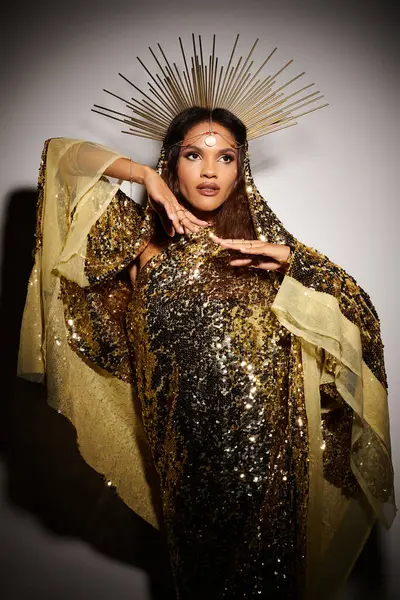 A stunning African American goddess exudes grace in a shiny golden dress, illuminated in a studio setting. — Stock Photo