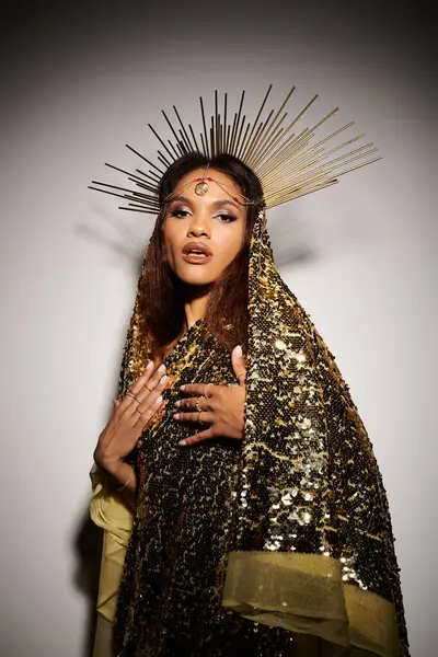 An enchanting goddess captivates in a radiant golden dress and intricate accessories, showcasing timeless elegance. — Stock Photo