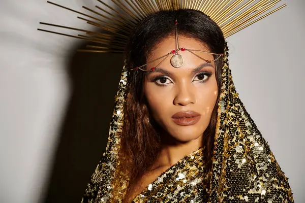 A radiant African American goddess exudes elegance in a shiny golden dress, adorned with striking accessories. — Stock Photo