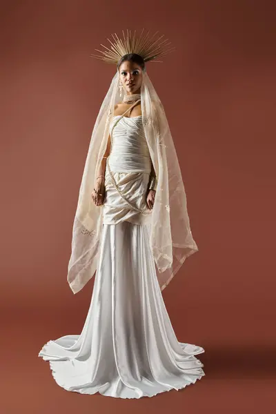 A beautiful African American woman in a white gown and pearl necklace poses gracefully against a brown backdrop. — Stock Photo