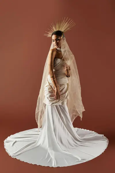 A beautiful African American woman embodies grace in a flowing white dress and pearl necklace against a warm backdrop. — Stock Photo