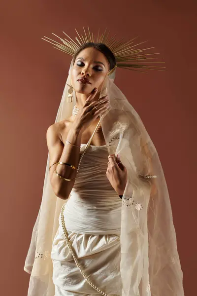 This captivating woman in a white dress and pearl necklace exudes grace and confidence against a brown backdrop. — Stock Photo