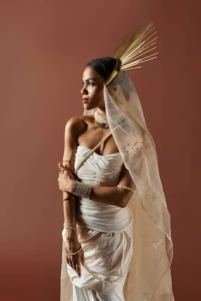 A stunning African American woman stands elegantly in a white dress, radiating grace with a pearl necklace. — Stock Photo
