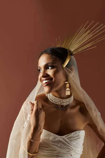 A stunning African American woman in a white dress and pearl necklace exudes grace in a warm studio setting. — Stock Photo