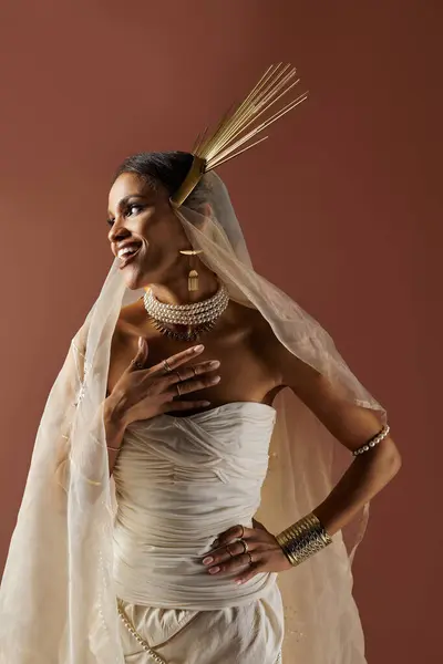 The beautiful woman showcases her elegance in a flowing white dress, adorned with pearls, radiating confidence. — Stock Photo