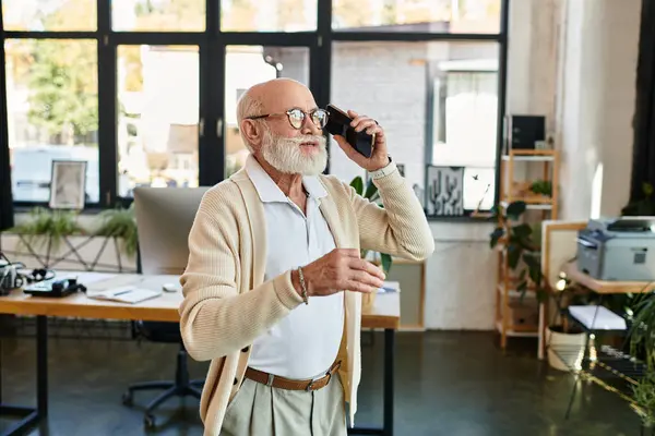 A stylish senior manager discusses business matters on the phone while standing in a contemporary office. — Stock Photo