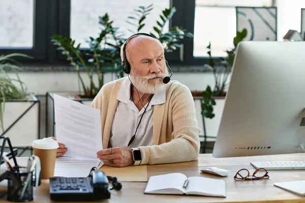 Un anziano uomo d'affari ben vestito con la barba si concentra sui compiti in una scrivania contemporanea. — Foto stock