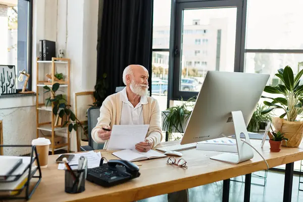 A well-dressed older professional reviews paperwork thoughtfully in a bright, contemporary office space. — Stock Photo