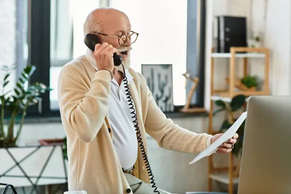 A sharp-dressed senior manager reviews notes and discusses key details over the phone. — Stock Photo