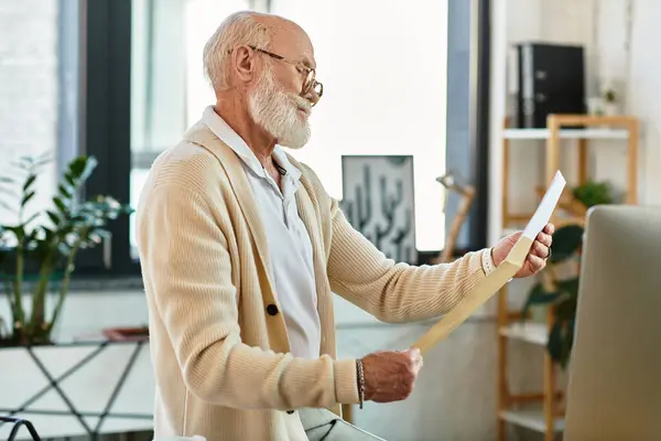 A experienced businessman with a beard analyzes important documents while seated in a stylish office. — Stock Photo