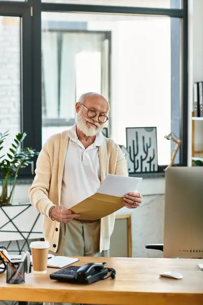 A senior businessman with a beard examines paperwork in a stylish office, showcasing professionalism and elegance. — Stock Photo