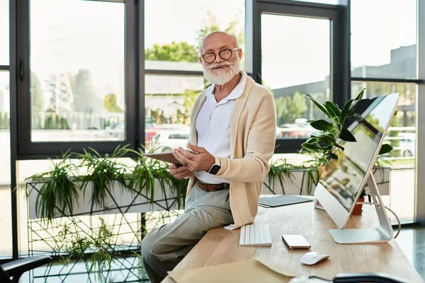 A well-dressed senior businessman with a beard actively reviews documents while standing in a bright office. — Stock Photo