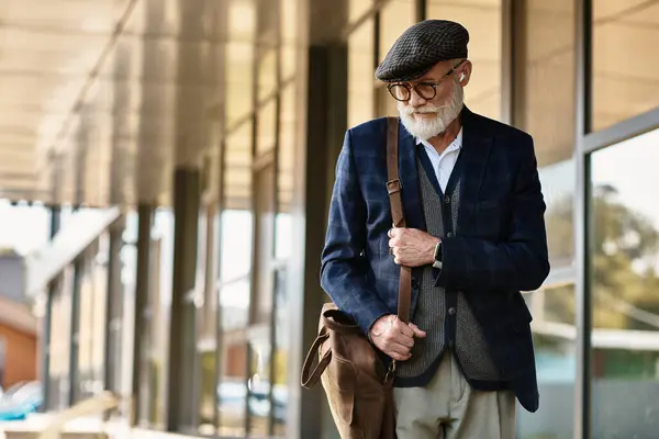 Ein modischer älterer Mann mit Bart steht an einem Herbsttag elegant vor einem modernen Gebäude.. — Stockfoto