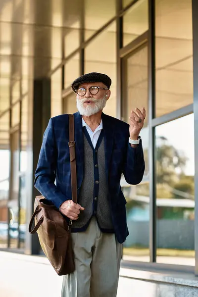 Ein modischer älterer Herr schlendert selbstbewusst an einer modernen Struktur vorbei, die herbstlichen Charme versprüht. — Stockfoto