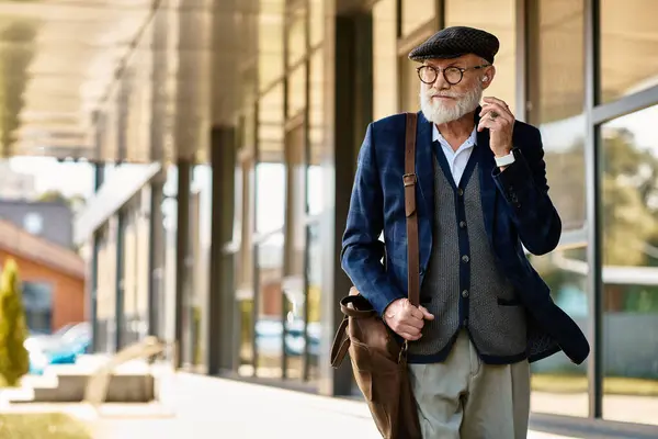 A distinguished senior man in a checkered blazer strolls thoughtfully outside a sleek modern building. — Stock Photo