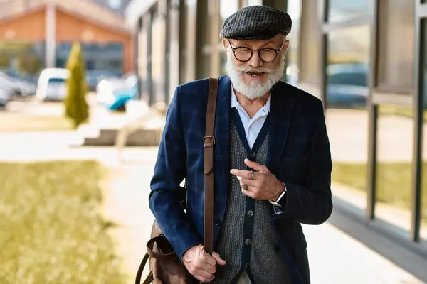 A fashionable senior gentleman strolls outside a contemporary building, exuding charisma in autumn attire. — Stock Photo