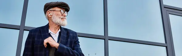 A distinguished older man stands confidently in autumn attire, radiating style against a contemporary backdrop. — Stock Photo