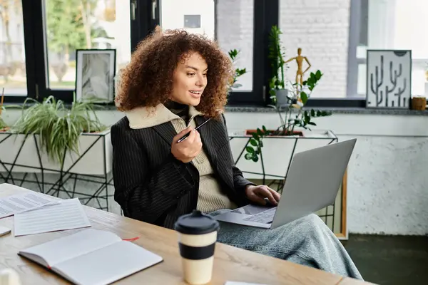 A young woman participates in a discussion using her laptop in a stylish, bright environment. — Stock Photo