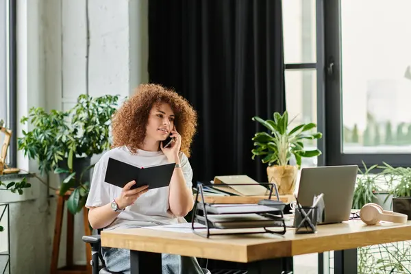 A woman talks on the phone, writing notes in a cozy workspace filled with plants. — Stock Photo