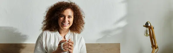The woman enjoys a quiet moment with her mug, radiating joy in a bright room. — Stock Photo