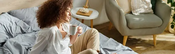 A woman relaxes with a cup of coffee in her comfortable living space, capturing tranquility. — Stock Photo