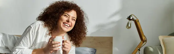 A mulher vigas com felicidade como ela bebe sua bebida quente em um quarto confortável. — Fotografia de Stock