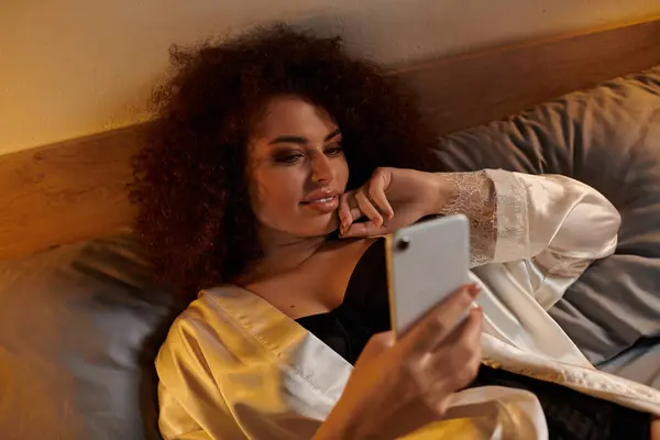 The woman enjoys her leisure time, lost in thought as she uses her smartphone. — Stock Photo