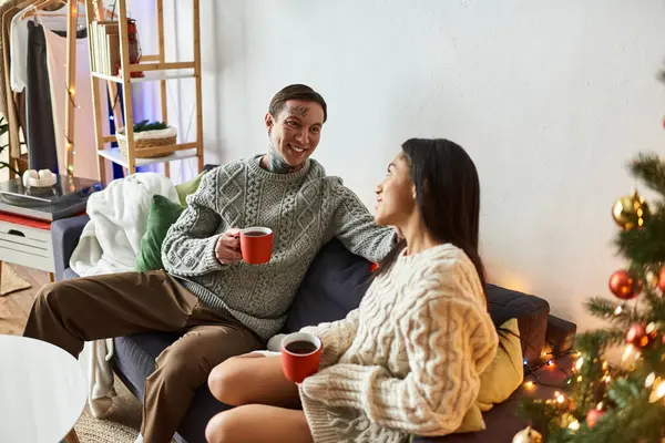 A couple enjoys warm beverages together, surrounded by festive decorations and holiday cheer. — Stock Photo