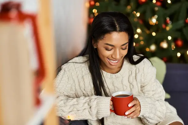 A woman cherishes a warm drink, surrounded by festive decorations and joyful vibes. — Stock Photo