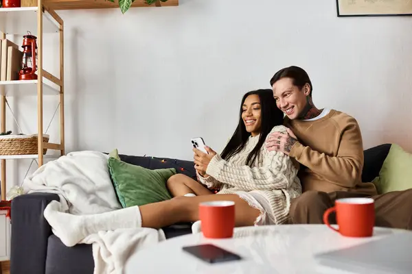 A couple enjoys each others company at home, sharing smiles and warm drinks during Christmas. — Stock Photo