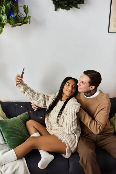 A loving couple celebrates Christmas by taking a joyful selfie in their cozy living room. — Stock Photo