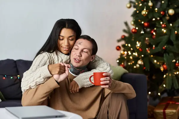 A couple enjoys a cozy Christmas together, exchanging laughter and love by the festive tree. — Stock Photo