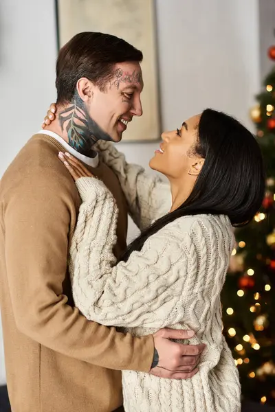 A couple embraces with joy and love, celebrating the warmth of Christmas at home. — Stock Photo