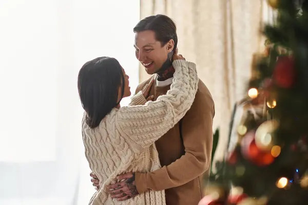 A couple enjoys a cozy moment together in their home, surrounded by holiday cheer and decorations. — Stock Photo
