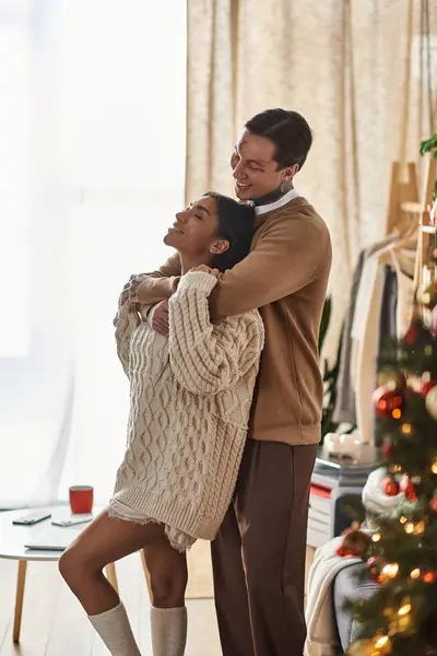 A couple shares a tender moment during Christmas surrounded by festive decorations. — Stock Photo