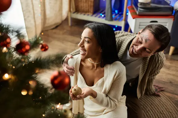 Un couple amoureux partage le rire tout en décorant leur maison pour une célébration de Noël festive. — Photo de stock