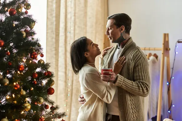 A couple shares a tender moment while celebrating Christmas surrounded by decorations. — Stock Photo
