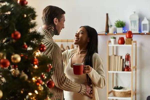 A couple enjoys a heartwarming moment during Christmas at their beautifully decorated home. — Stock Photo