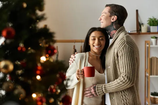 A couple shares a loving moment at home, surrounded by Christmas decorations and joy. — Stock Photo