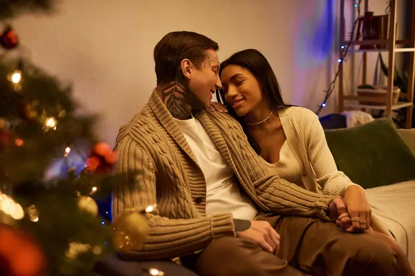 A couple enjoys a cozy moment together, embracing the warmth of the holiday spirit. — Stock Photo